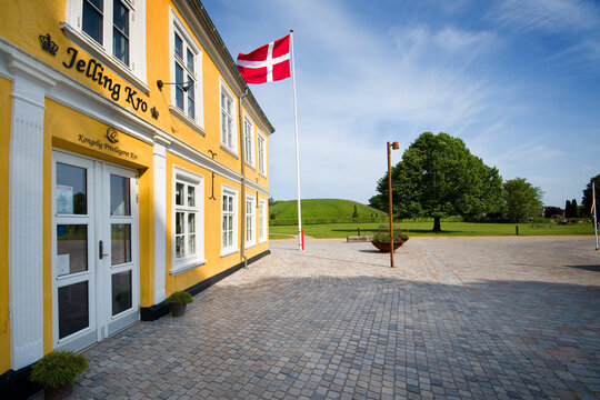 Jelling Kro restaurant and Viking Age burial mounds in the background in Jelling, Denmark