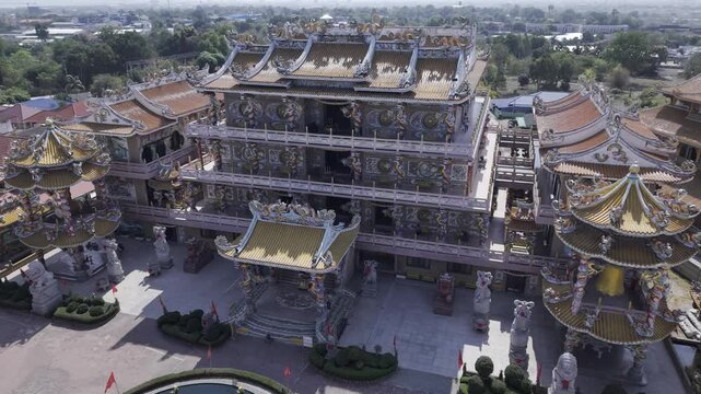 High angle drone shot of Na Jasaataichue Shrine, famous Chinese style architecture temple with golden roofs in Thailand.