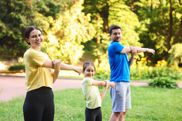 Obraz premium Happy family doing morning exercises in park, selective focus