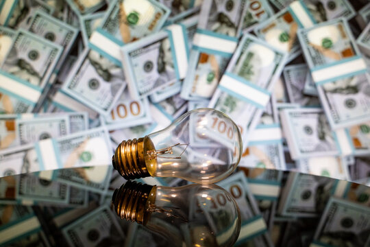 Close up of light bulb with dollar banknotes background.