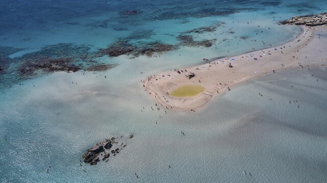 Overtourism, Aerial view of a sandbank in the sea with people swimming and relaxing in the clear water, Elafonissi, lagoon, south-west tip of Crete, Crete, Greek Islands, Greece