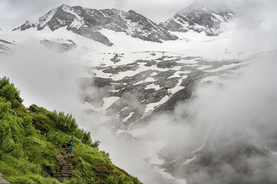 Mountaineers on a hiking trail, in the background glaciated peak Dosso Largo and glacier Schlegeiskees, cloudy atmospheric mountain landscape, ascent to Furtschaglhaus, Berliner H&ouml;henweg, Zillertal, Tyrol, Austria