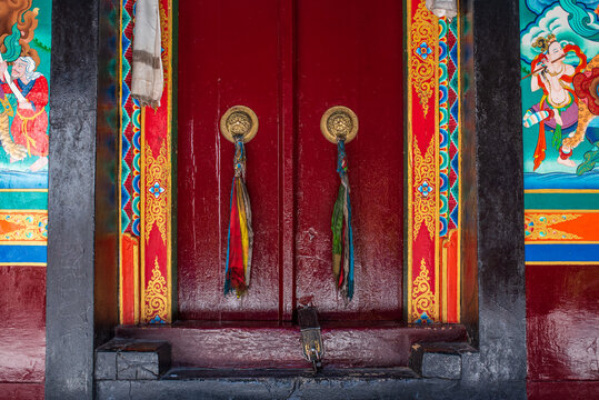 Ancient decorated red door of a Tibetan Buddhist temple