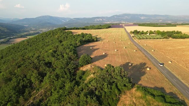 Cinematic aerial panorama of lavender fields, hay bales and rolling farmland in Valensole, Provence, France