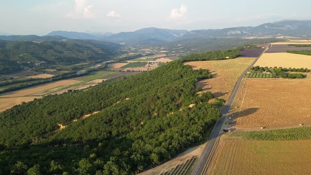 Cinematic aerial panorama of lavender fields, hay bales and rolling farmland in Valensole, Provence, France