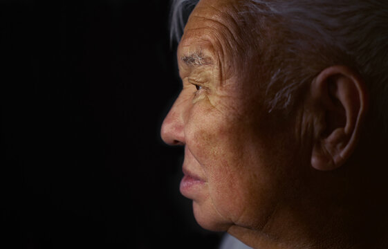 Close-up of elderly man's profile in shadow