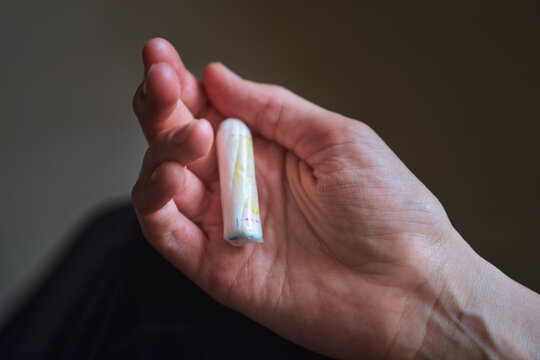 Hand holding tampon symbolizes female health