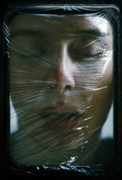 Surreal woman face wrapped in plastic fine art portrait