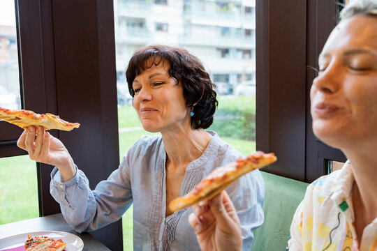 Women enjoying lunch break with pizza