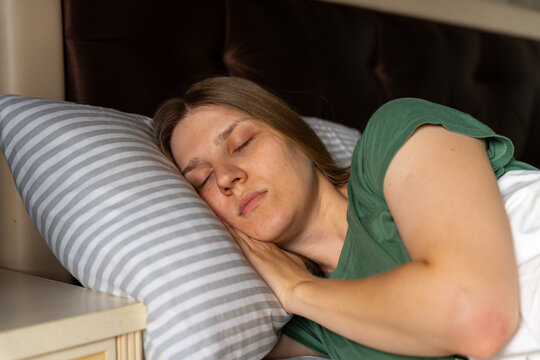 Peaceful woman sleeping on pillow in cozy bedroom