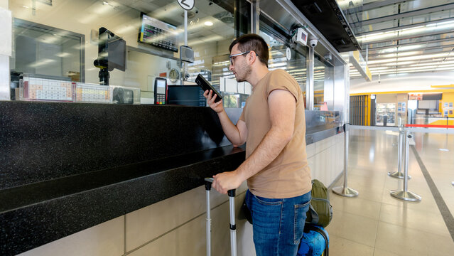 Man buying Taiwan train ticket using mobile translator app