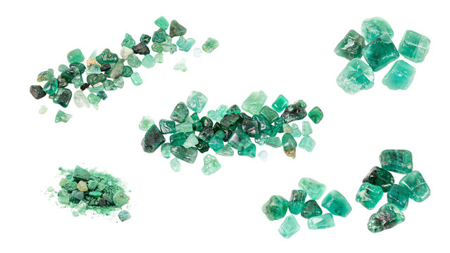 Raw emerald crystals and green gemstone fragments on white background