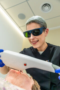 Senior woman receiving laser facial skin care treatment
