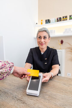Client paying by card at reception desk in beauty center