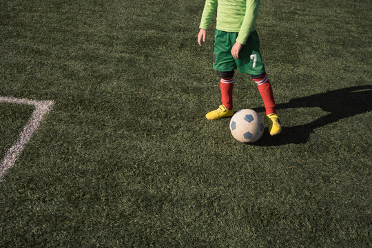 Boy playing football on a sunny day outside