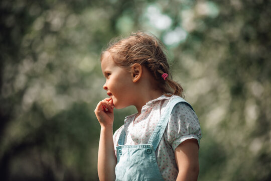 Young girl outdoors in spring with blooming bokeh background