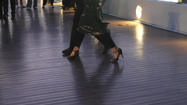 Low angle view of the legs and feet of a professional couple dancing tango. Passionate performers showing intricate footwork on a stage