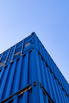 Low angle view of blue shipping container against sky