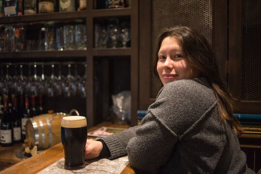 Woman enjoying a beverage in a cozy London pub