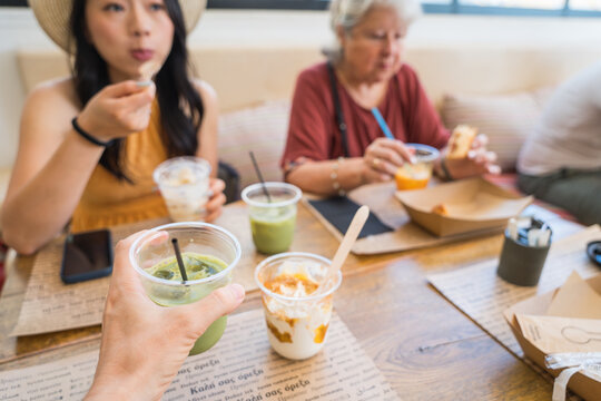 Friends enjoying smoothies and dessert at a casual cafe table