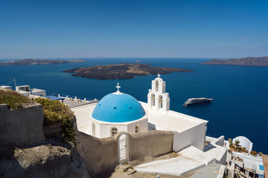 Greek island church with blue dome above the Aegean sea