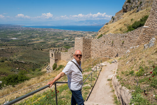 Tourist at Acrocorinth fortress ruins overlooking Corinth