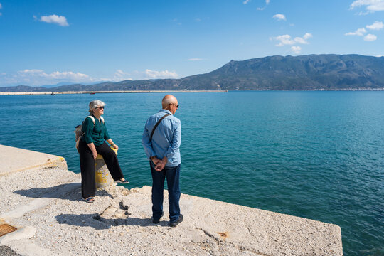 Tourists on Corinth waterfront with mountain view, Greece