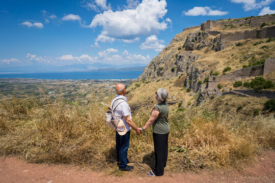 Tourist couple gazing at Acrocorinth fortress, Greece