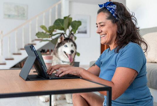 Woman working from home with husky dog by her side