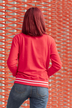 Woman in red sweatshirt against textured backdrop