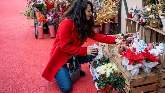 Woman shopping for Christmas gifts at festive flower market