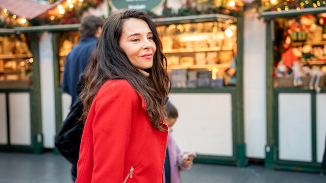 Woman shopping at Christmas market with festive lights