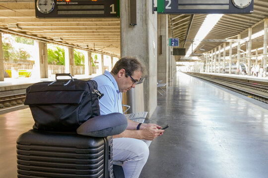 Mature traveler awaits train in modern station