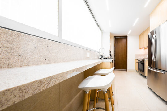 Bright modern kitchen with granite counter and stools
