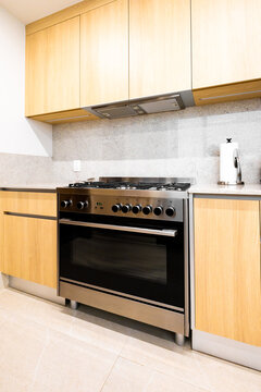 Modern kitchen stove and oven with wood cabinet detail