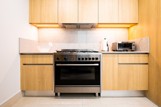 Modern kitchen interior with oven, wood cabinet and light