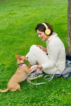 Woman with adopted dog sitting in park