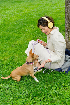 Woman bonding with adopted dog in green park