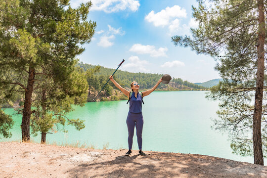 Joyful hiker at mountain lake with outstretched arms