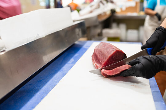 Fishmonger slicing fresh tuna at Lisbon fish market