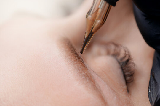 Permanent microblading procedure on female eyebrow enhancement, white light