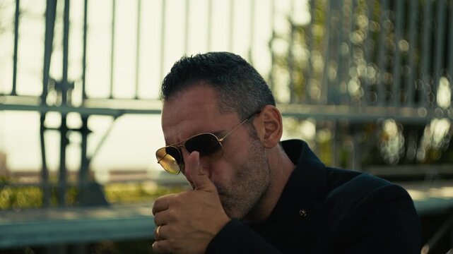 mafia boss lights a cigar with a defiant look