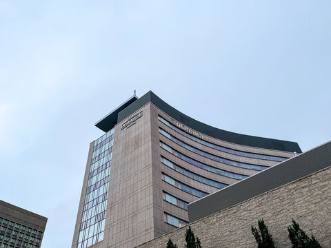 Low angle shot showing upper facade of modern curved Desmarais Building at uOttawa with text logo, June 2026