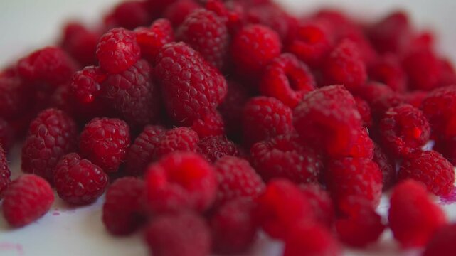 Fresh raspberries falling in slow motion isolated on a white background, concept of healthy diet and vitamin-rich food