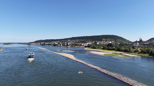 Wide drone aerial view of the Rhine River between Bingen am Rhein and Rudesheim, Germany, featuring river islands, rocky shallows, vineyards and the scenic landscape of the Upper Middle Rhine Valley