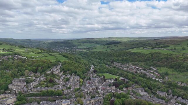 Panoramic high aerial view of the Calder valley in West Yorkshire showing the town of Hebden Bridge and the village of Mytholmroyd in summer showing the local landscape with meadows between woodland