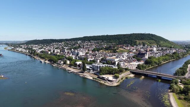 Drone aerial view of Bingen am Rhein at the confluence of the Rhine and Nahe rivers in Germany. Scenic cityscape with historic architecture, waterfront, bridges, green hills and vineyards in the Upper
