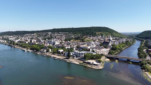 Drone aerial view of Bingen am Rhein at the confluence of the Rhine and Nahe rivers in Germany. Scenic cityscape with historic architecture, waterfront, bridges, green hills and vineyards in the Upper