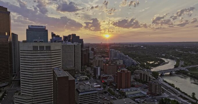 Calgary AB Canada Aerial v49 reverse flyover East Village capturing urban cityscape of Eau Claire, Chinatown and Downtown with beautiful summer sunset skyline - Shot with Mavic 3 Pro Cine - July 2023