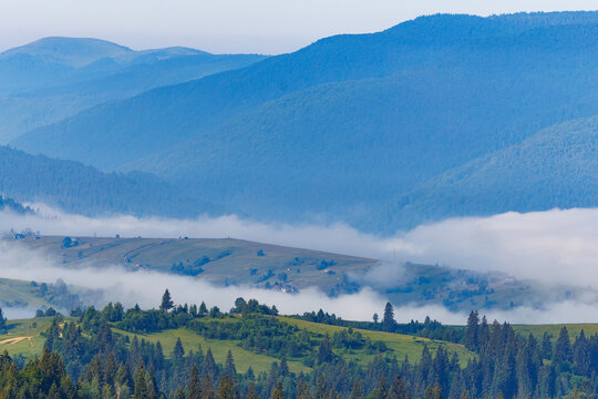 Misty morning in the Carpathian mountains with thick fog in the valley.
